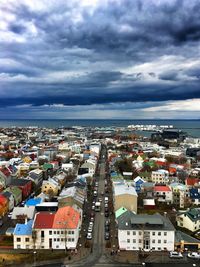 High angle view of townscape by sea against sky