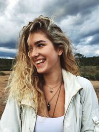 Portrait of smiling young woman against sky