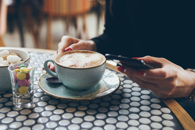 Midsection of coffee cup on table at cafe