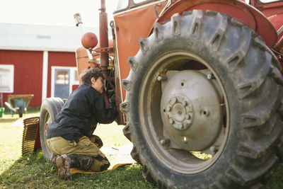 Woman repairing tractor