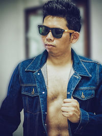 Portrait of young man wearing sunglasses standing outdoors