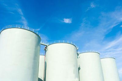 Low angle view of storage compartments of factory against sky