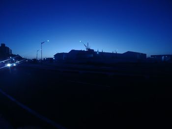 Illuminated city against clear sky at night