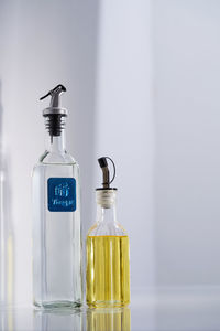 Close-up of glass bottle on table against wall