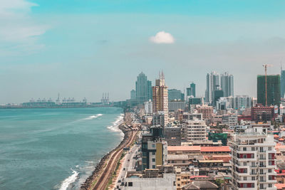 Aerial view of buildings in city against sky