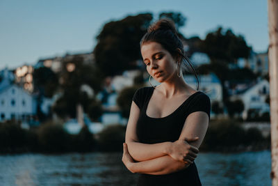 Young woman standing outdoors against sky