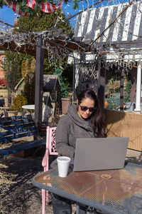 Woman using laptop on table at cafe