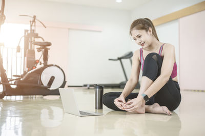 Young woman using phone while sitting on table