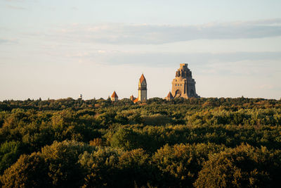 Monument of the battle of the nations with the cemetry church over the treeline