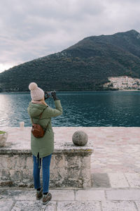 Rear view of woman looking at sea against sky