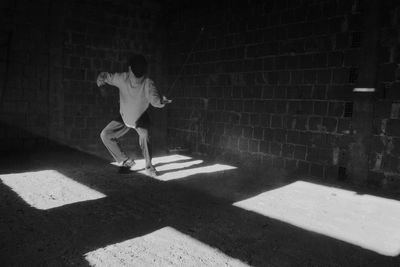 Man with sword practicing in darkroom