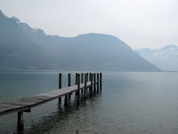 Pier over lake against mountains