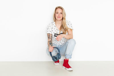 Portrait of woman sitting against white background