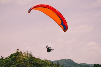 Person paragliding against sky