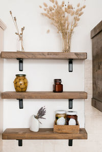 Wooden shelves in the scandinavian kitchen. dried flowers, cans of canned vegetables, jars of jam