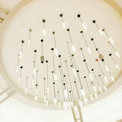Low angle view of illuminated light bulbs hanging from ceiling