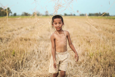 Portrait of smiling boy standing on field