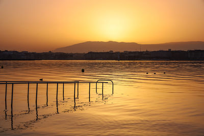 Scenic view of lake against orange sky