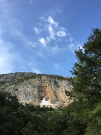 Distant view of ostrog monastery by rock formations against sky