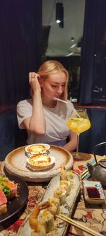 Young woman sitting on table at restaurant