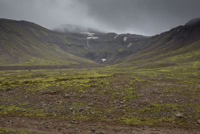 Scenic view of mountains against cloudy sky