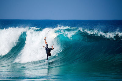 Man surfing in sea against sky