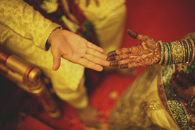 Close-up of couple holding hands during wedding