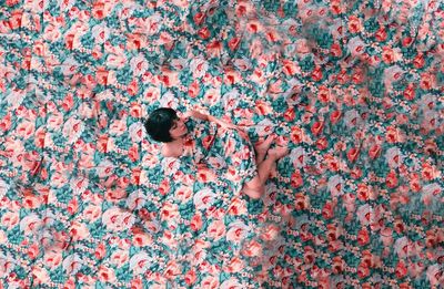 High angle view of woman lying down on floral background