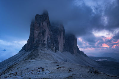 Rock formations against cloudy sky