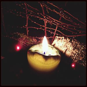 Close-up of lit candle in dark room