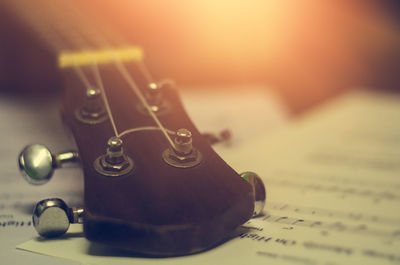 Close-up of guitar headstock on sheet music