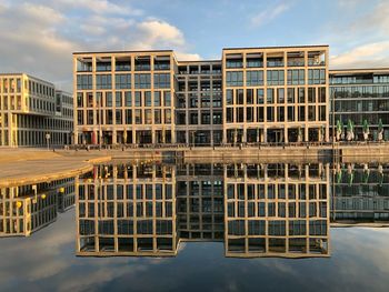 Reflection of building in lake against sky