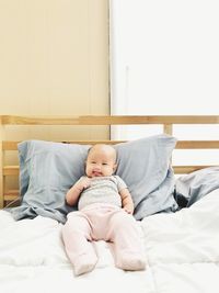 Full length of baby lying on bed