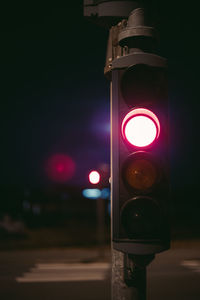 Illuminated street light on road at night