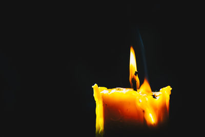 Close-up of yellow candle against black background