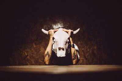 Man covering face with hunting trophy