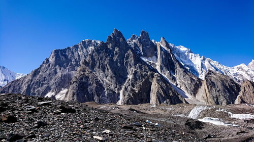 Scenic view of snowcapped mountains against clear blue sky