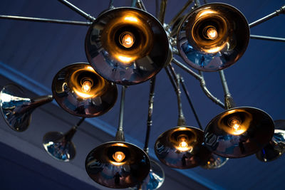 Low angle view of illuminated chandelier hanging from ceiling