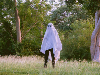 Rear view of woman standing on field