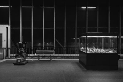 Man sitting on empty seat in illuminated city at night