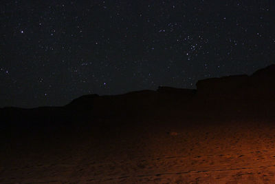 Scenic view of landscape against star field at night