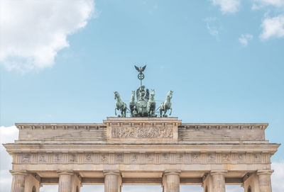 Brandenburg gate with quadriga statue against blue sky