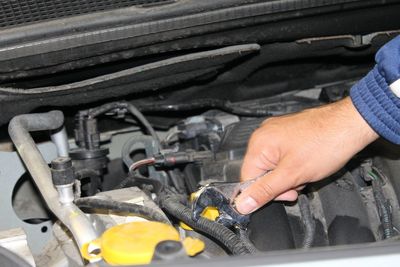 Cropped hand repairing car engine