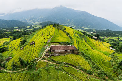 Scenic view of green landscape and mountains against sky