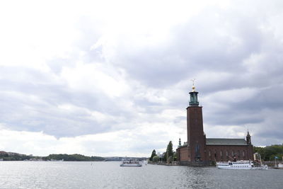 Lighthouse on building against cloudy sky