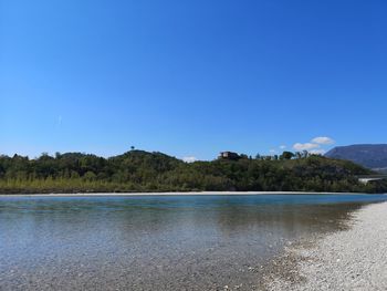 Scenic view of lake against clear blue sky