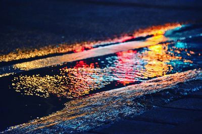 Reflection of city lights on puddle