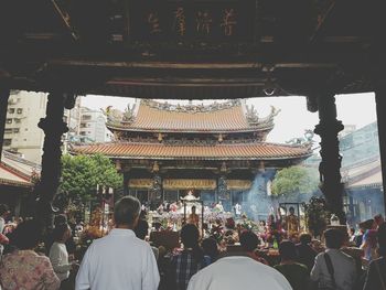 People at temple against sky