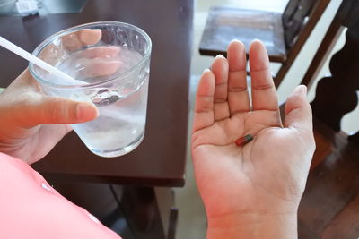 Midsection of man drinking glass with water