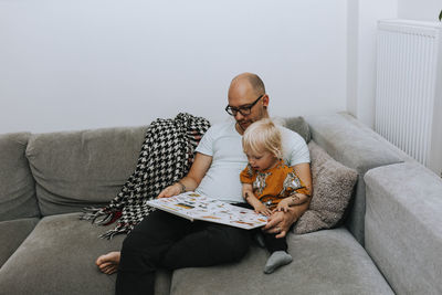 Full length of man sitting on sofa